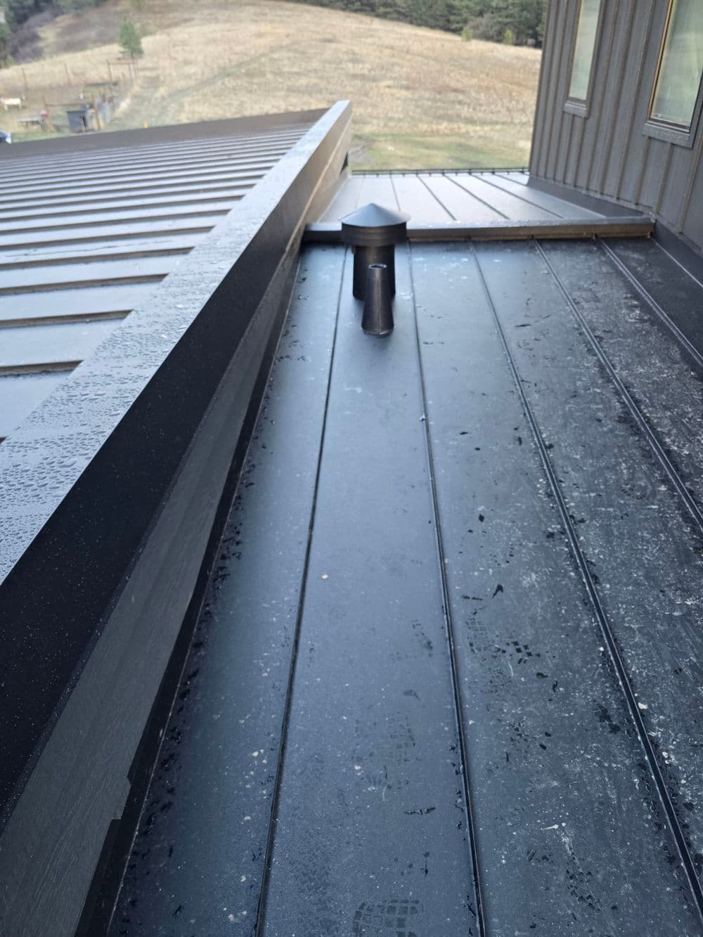 Range hood exhaust in a standing seam metal roof.